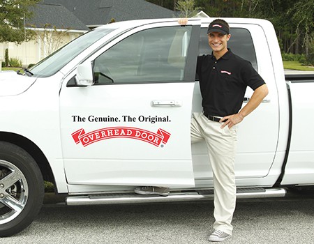 Overhead Door Co. installer standing next to company truck